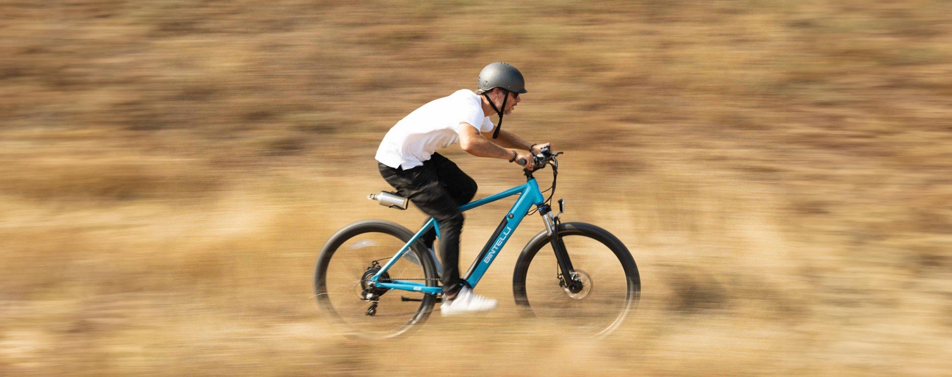 A man riding his Bintelli B2 Electric Bike through a trail