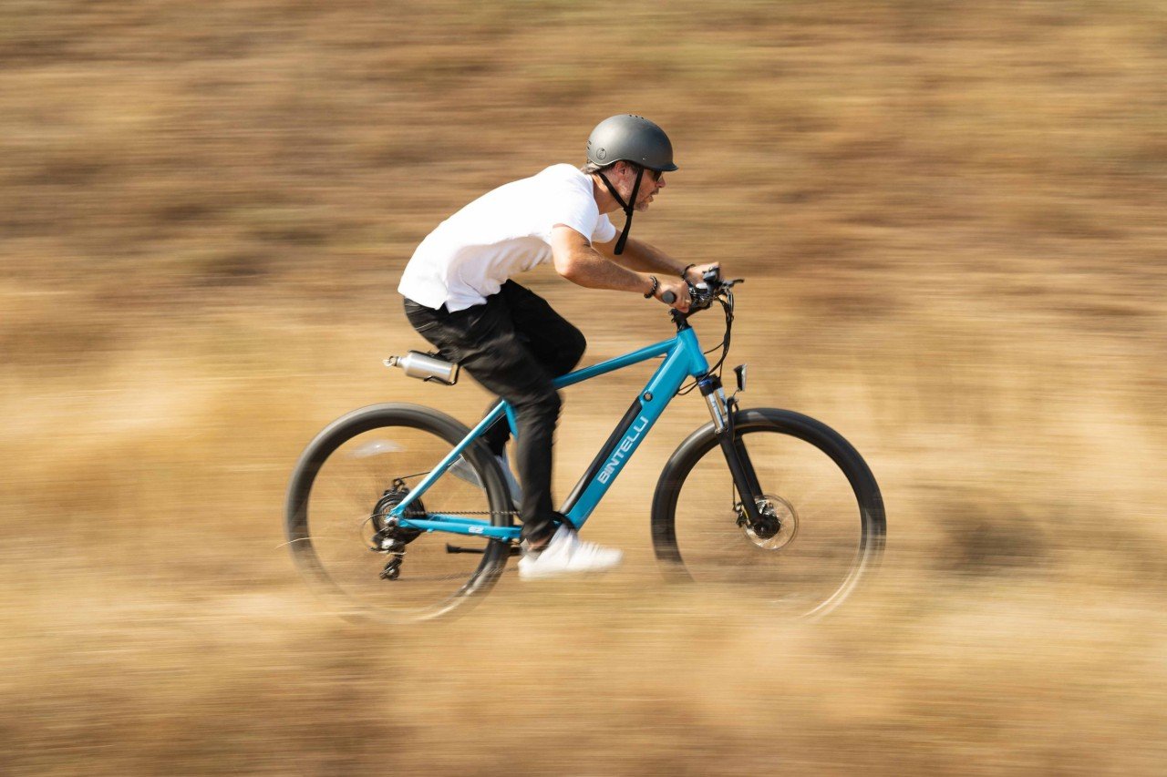 A man riding his Bintelli B2 Electric Bike through a trail