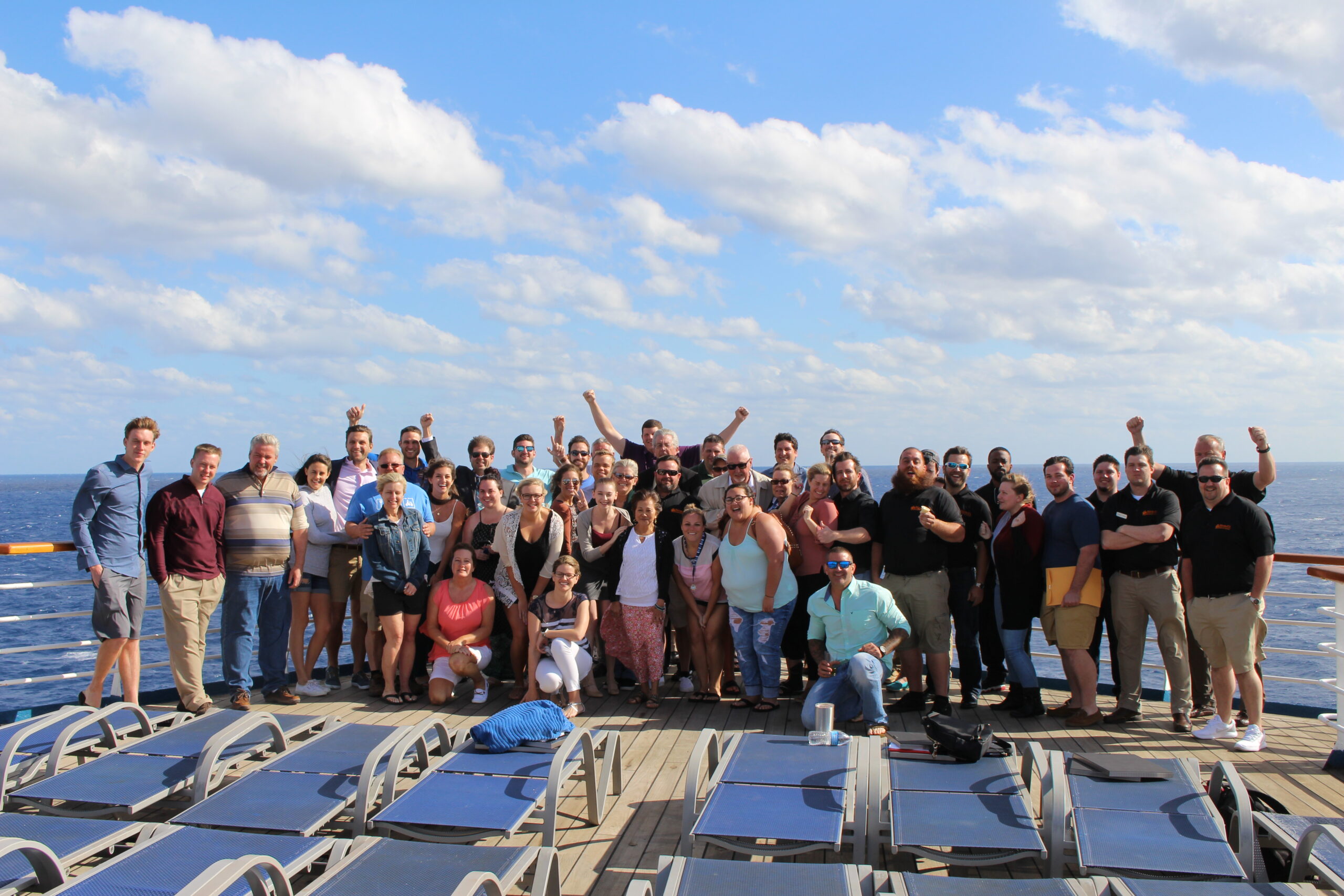 The Bintelli golf carts team gathers on a boat in the ocean celebrating a great year of selling golf carts.